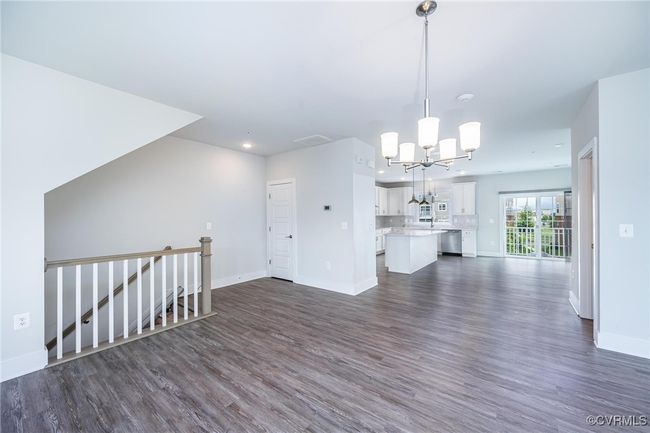 living room featuring a chandelier, dark wood-type flooring, and recessed lighting | Image 7