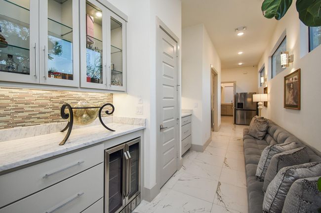 Hallway features built-in cabinetry & beverage fridge. | Image 40