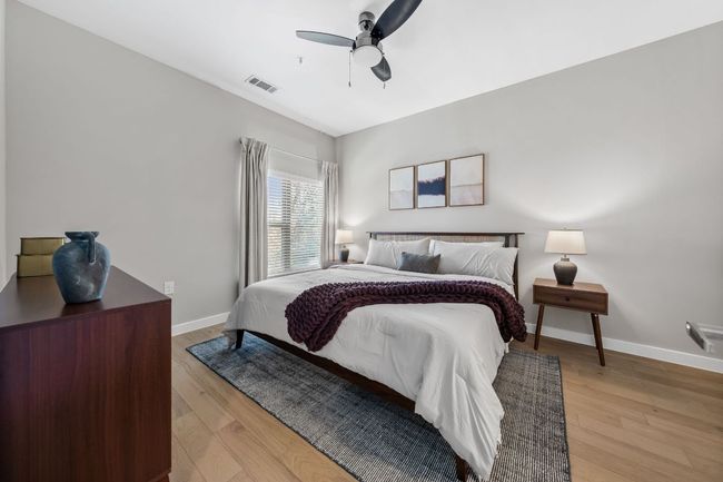 Bedroom with visible vents, baseboards, light wood-style floors, and ceiling fan | Image 17