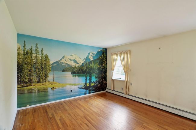 Unfurnished room with a baseboard radiator, a water and mountain view, and wood finished floors | Image 20
