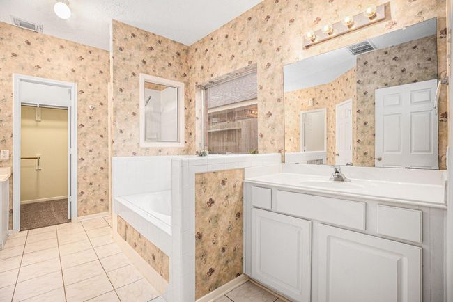Primary ensuite offers two separate vanity sinks, jetted tub, and seperate shower. | Image 23