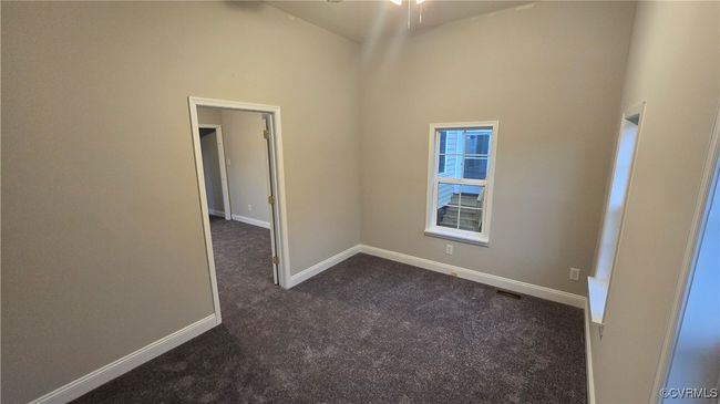 Spare room featuring baseboards, dark carpet, visible vents, and high vaulted ceiling | Image 47