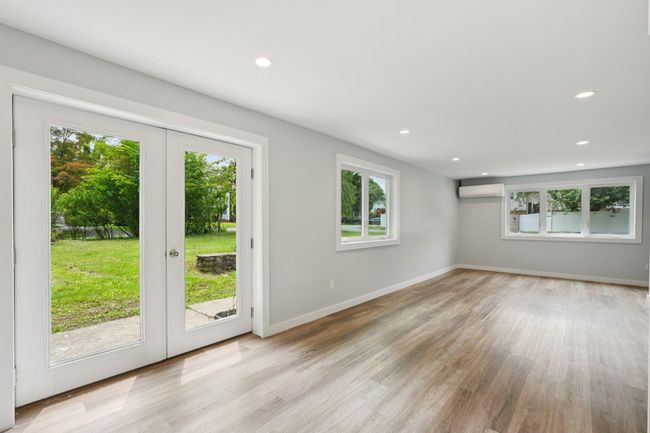 French doors leading to side yard. AC/Heat mini split, french doors, wood finished floors, and recessed lighting | Image 6