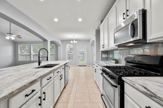 Pull up a stool at the island—cook, serve, and stay connected to the breakfast nook and backyard views. | Image 14