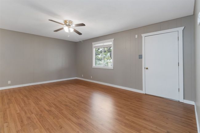 Empty room featuring light wood-style flooring, baseboards, and ceiling fan | Image 9