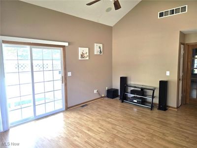 Great room with ceiling fan, vaulted ceiling, and laminate wood flooring | Image 3