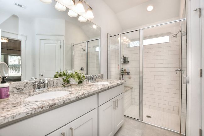Bathroom with a sink, visible vents, a shower stall, and double vanity | Image 22