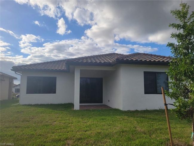 Back of property with a tile roof, stucco siding, and a yard | Image 30