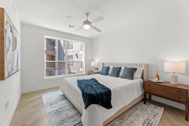 Bedroom with light wood-type flooring, ceiling fan, baseboards, and visible vents | Image 7
