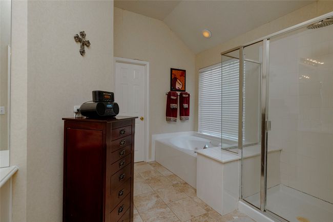 Full bath with a shower stall, vaulted ceiling, and a garden tub | Image 24