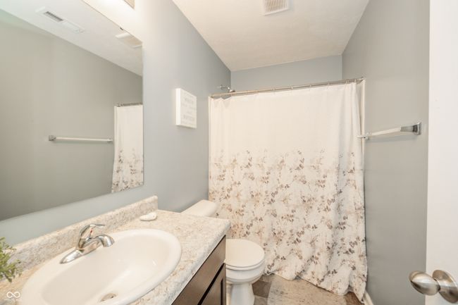 bathroom featuring toilet, vanity, and a shower with curtain | Image 27