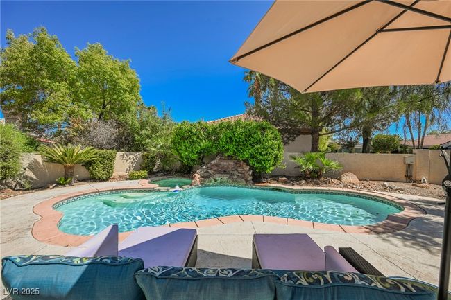 View of swimming pool featuring a patio area, a fenced backyard, and a pool with connected hot tub | Image 61