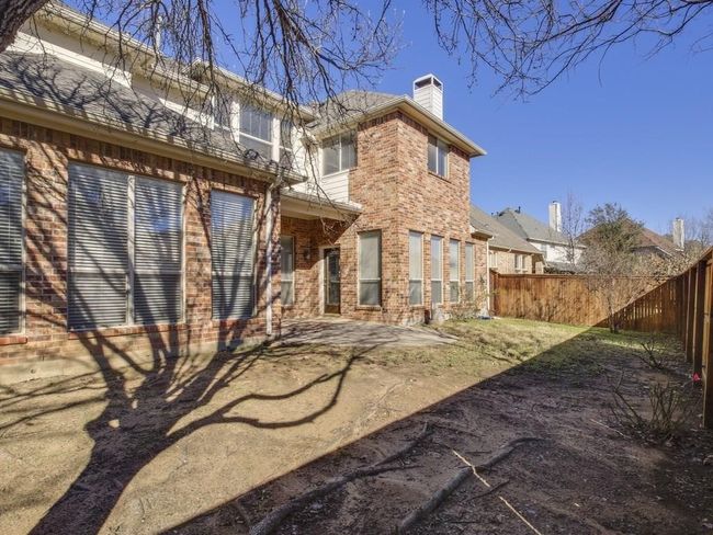 Rear view of house with a chimney, brick siding, and a patio | Image 12
