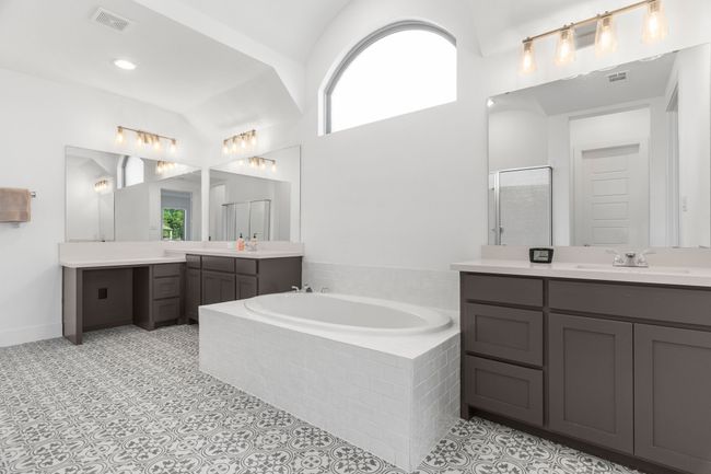 Full bath with plenty of natural light, a stall shower, a garden tub, two vanities, and vaulted ceiling | Image 32