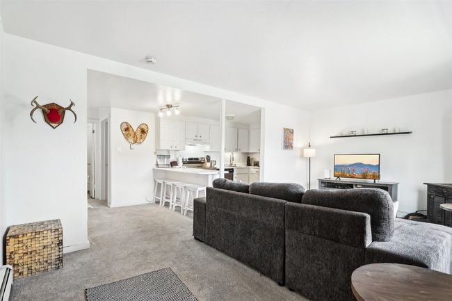 Living room featuring baseboards, light colored carpet, and baseboard heating | Image 6
