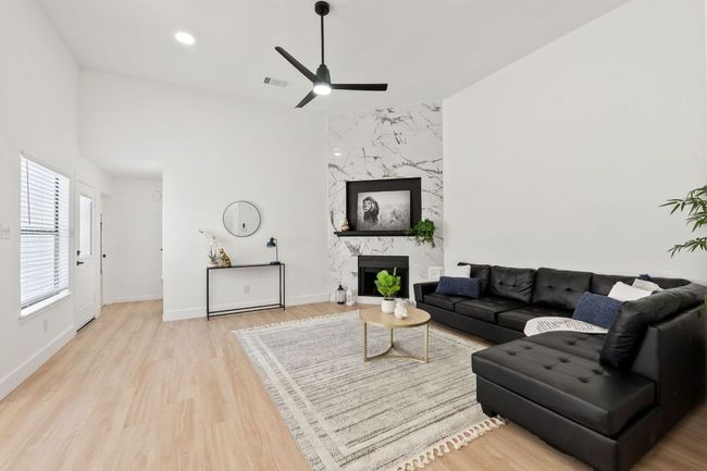 Living area featuring light colored waterproof finished floors baseboards, and ceiling fan | Image 5
