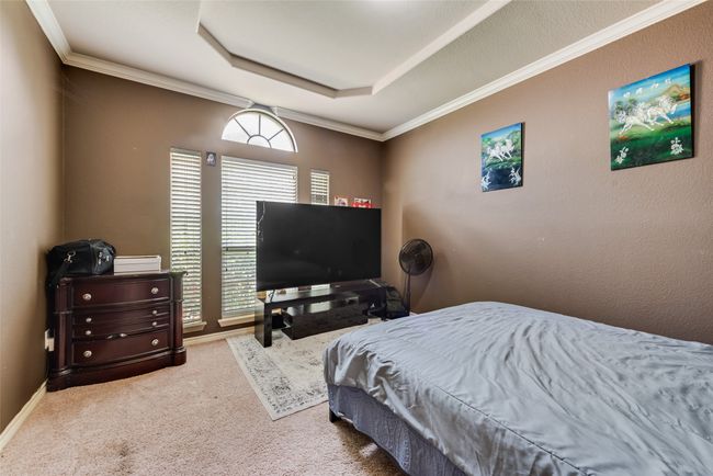 Bedroom featuring carpet, a raised ceiling, and crown molding | Image 14