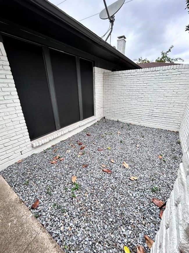 View of property exterior featuring brick siding and a chimney | Image 18