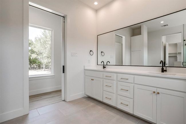 Bathroom featuring double vanity, tile patterned flooring, plenty of natural light, baseboards, and recessed lighting | Image 25