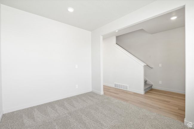 Below grade area featuring stairs, recessed lighting, wood finished floors, and carpet | Image 10