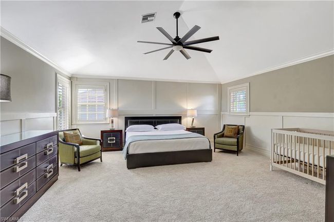 Bedroom featuring crown molding, visible vents, vaulted ceiling, carpet, and a decorative wall | Image 7
