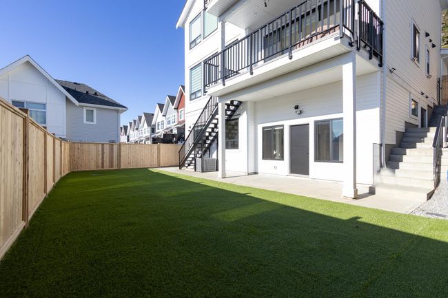 Fenced backyard featuring stairway, a balcony, a patio area, and a residential view | Image 10