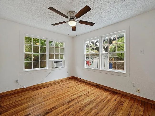 Unfurnished room featuring a textured ceiling, hardwood / wood-style floors, and a ceiling fan | Image 9