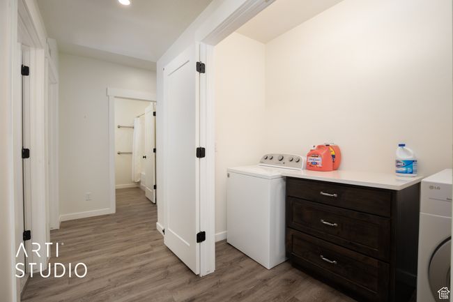 Laundry area with washer / dryer and light wood-type flooring | Image 34