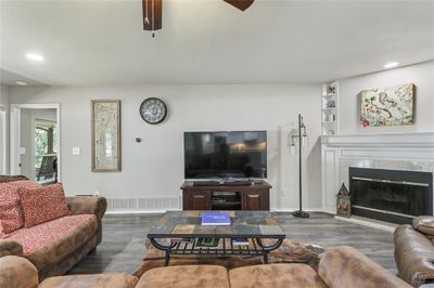 Living room featuring built in shelves, ceiling fan, dark hardwood / wood-style floors, and a high end fireplace | Image 2