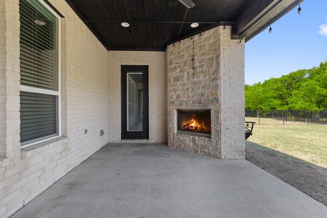 View of patio with fence and an outdoor stone fireplace | Image 28