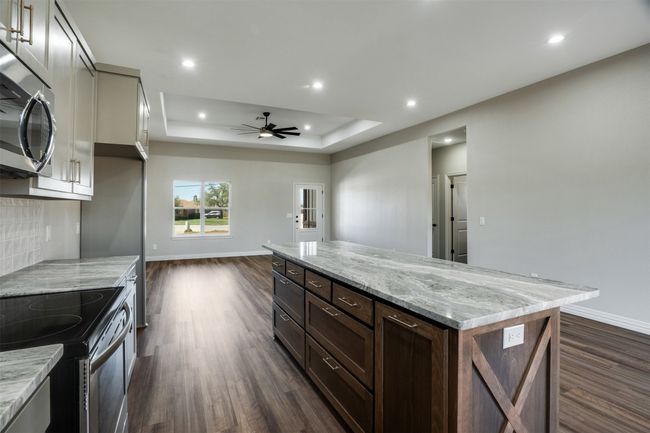 Kitchen with a ceiling fan, baseboards, dark wood-type flooring, and electric range | Image 10