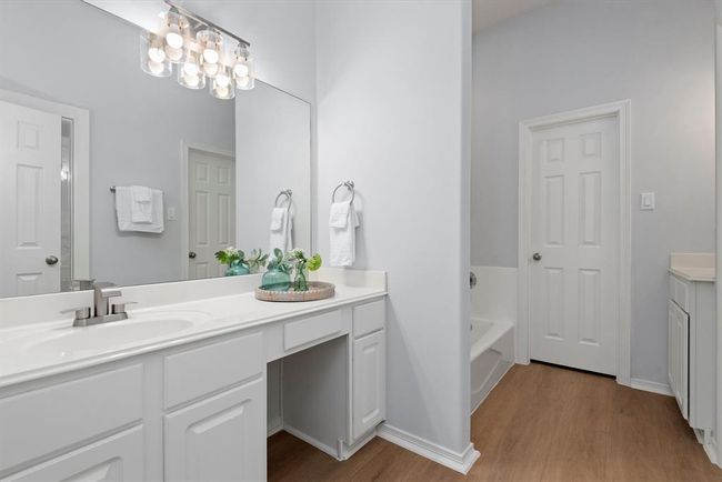 The primary bathroom offers 2 vanity areas and a separate tub and shower. | Image 20