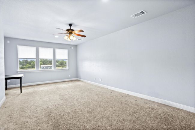 Carpeted spare room featuring a ceiling fan and baseboards | Image 30