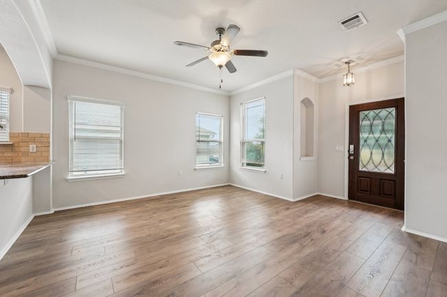 Entryway with hardwood / wood-style flooring, crown molding, a ceiling fan, arched walkways, and baseboards | Image 7