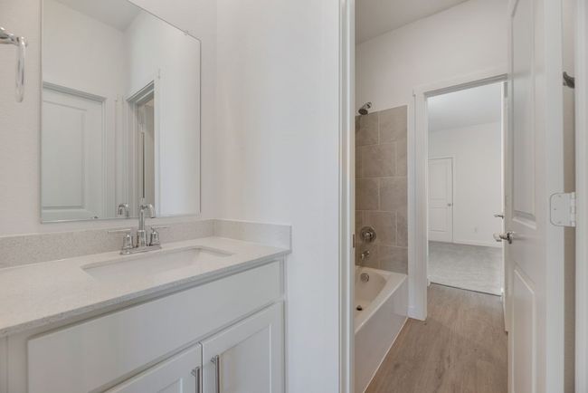 Full bath with vanity, wood finished floors, and washtub / shower combination | Image 10