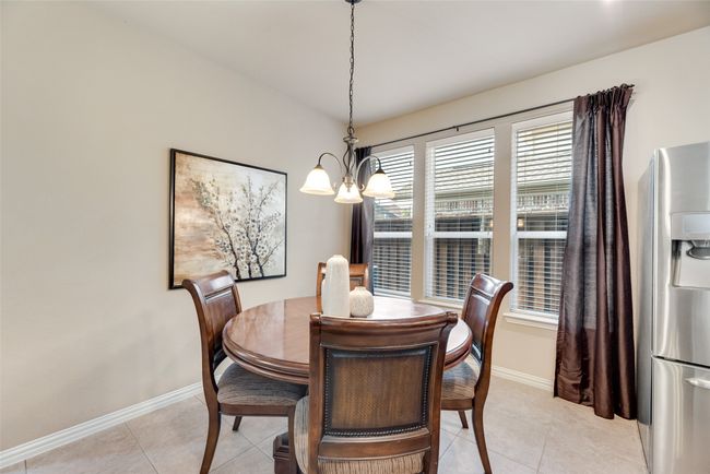 Dining area featuring a chandelier and light tile patterned floors | Image 7