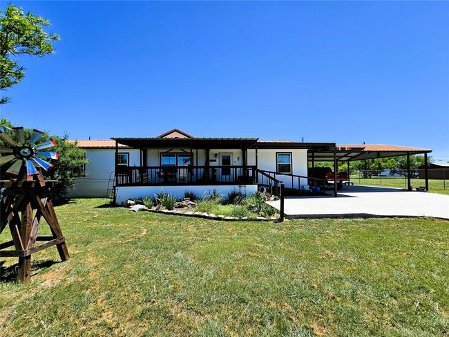 Back of house with a carport, concrete driveway, and stucco siding | Image 27
