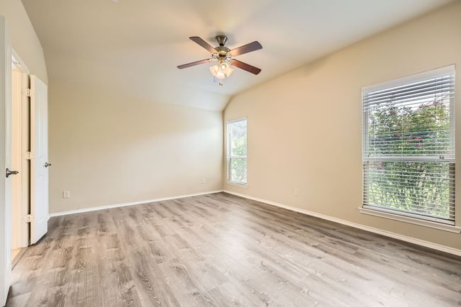 Unfurnished room with wood finished floors, ceiling fan, and vaulted ceiling | Image 13