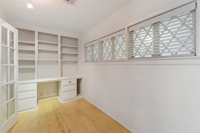 Unfurnished office with built in study area and wood finished floors | Image 24