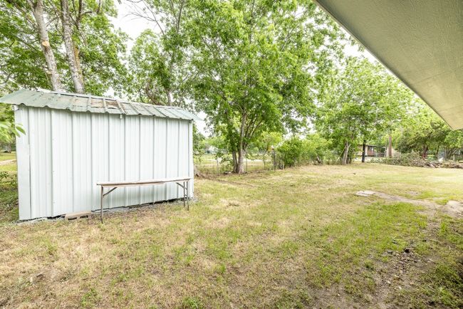 View of yard featuring a storage shed, an outdoor structure, and fence | Image 33