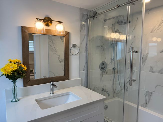 Bathroom featuring vanity and enclosed tub / shower combo | Image 29