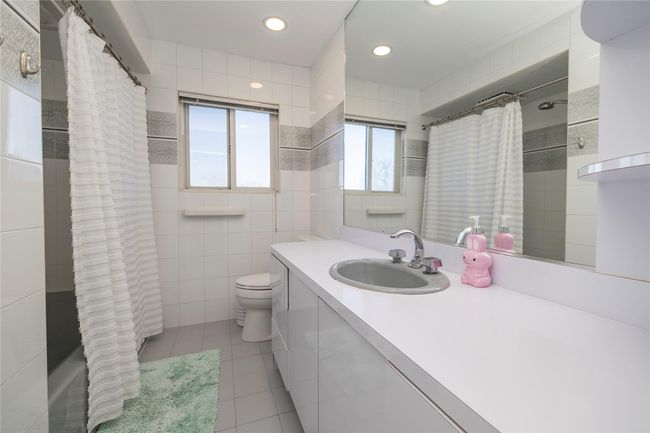 Bathroom with tile patterned flooring, vanity, tile walls, recessed lighting, and toilet | Image 18