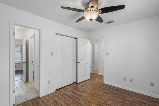 Unfurnished bedroom featuring ceiling fan, visible vents, wood finished floors, baseboards, and a closet | Image 22
