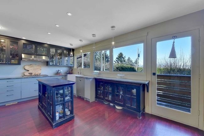 Bar with under cabinet range hood, dark wood finished floors, recessed lighting, decorative light fixtures, and appliances with stainless steel finishes | Image 13