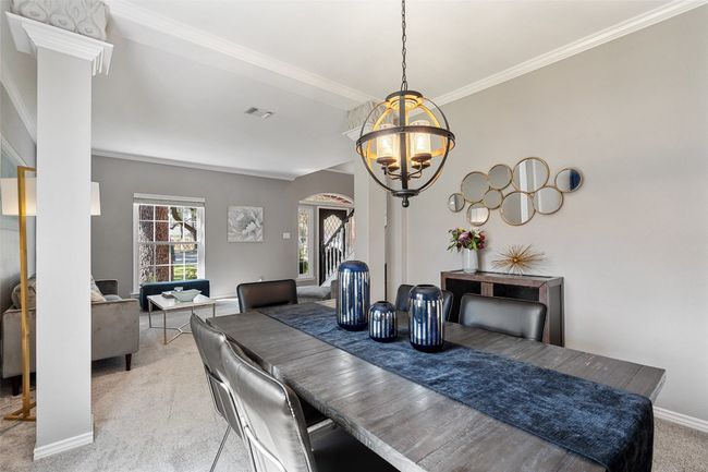 Dining room with light carpet, baseboards, a notable chandelier, and crown molding | Image 7