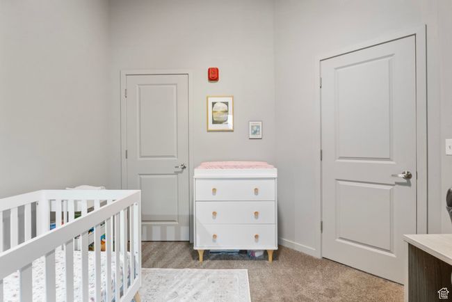 Bedroom featuring baseboards, a nursery area, and light colored carpet | Image 19