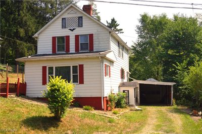 View of front of property featuring a carport and a garage | Image 1