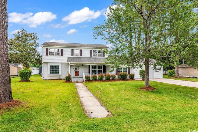 Traditional-style house featuring covered porch, driveway, a front yard, and roof with shingles | Image 34
