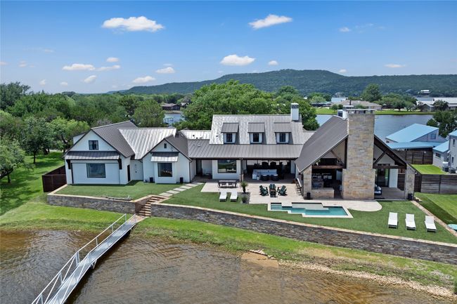 Rear view of property featuring a chimney, a patio, a water and mountain view, and an outdoor living space | Image 5