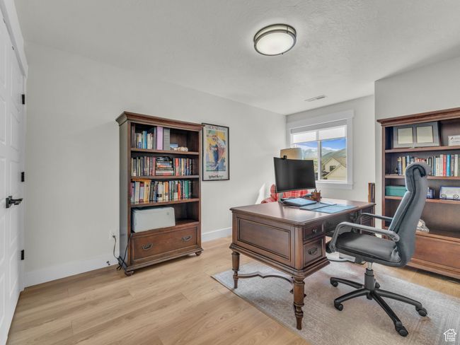 Office area featuring light wood-type flooring, baseboards, and a textured ceiling | Image 44